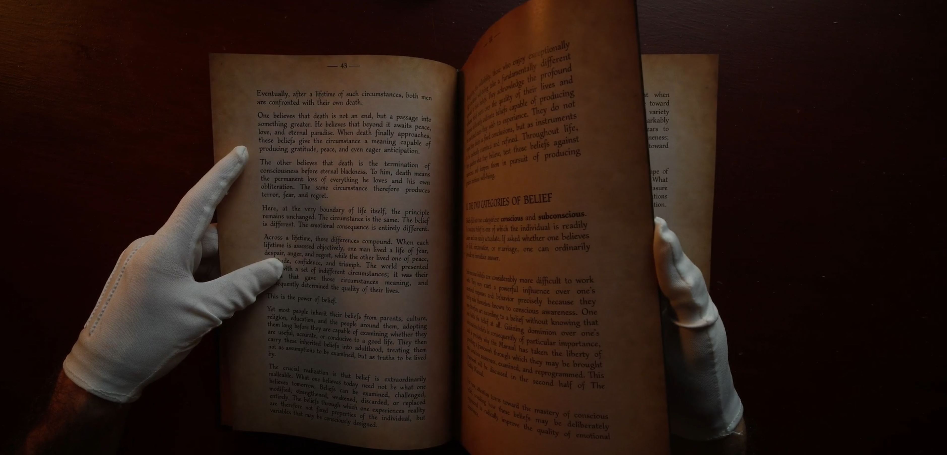 The Reality Manual open to a spread and handled with white archival gloves